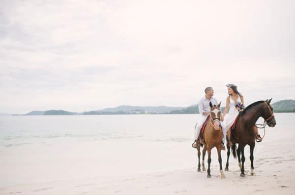 Newlyweds on the beach with horses