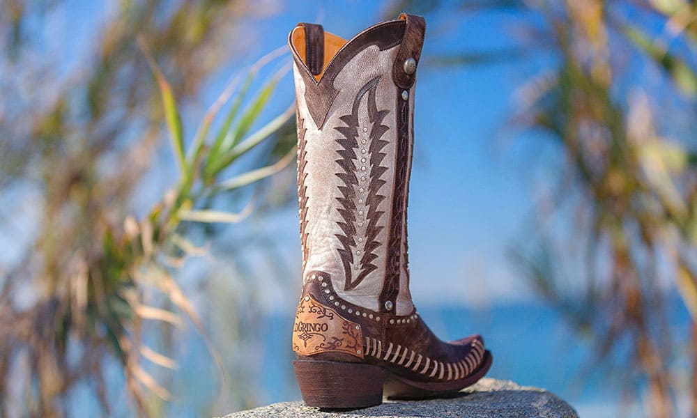 exotic brown and white boot in front of blue sky with palm trees in the background