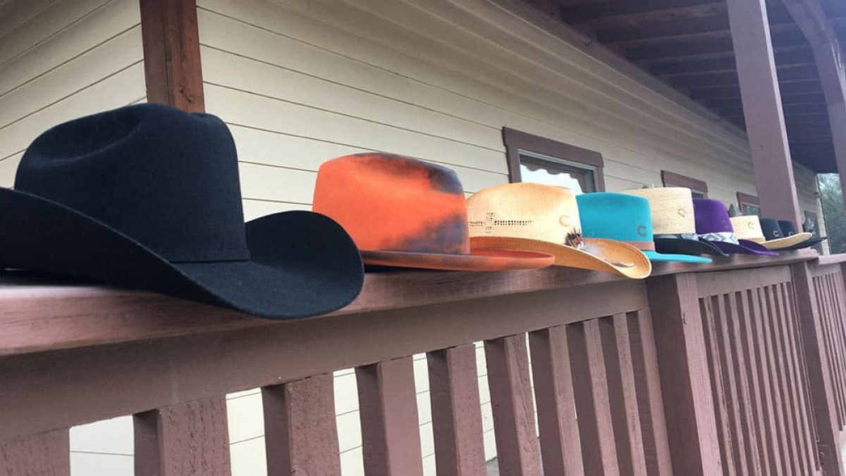 hats lined up on a fence