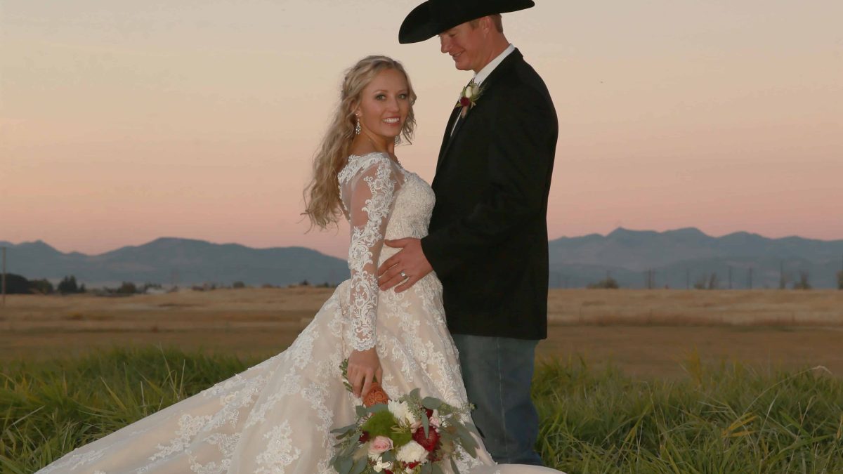bride with the sterling lane cierra frost chandelier earrings from Montana Silversmiths on her wedding day with her cowboy groom